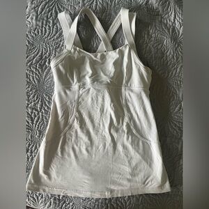 Lululemon white athletic top with detailing and pocket in the back.